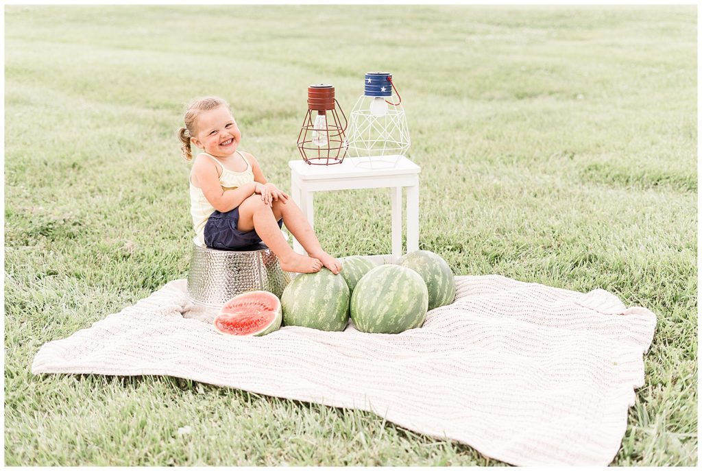 little girl sitting on bucket with watermelon