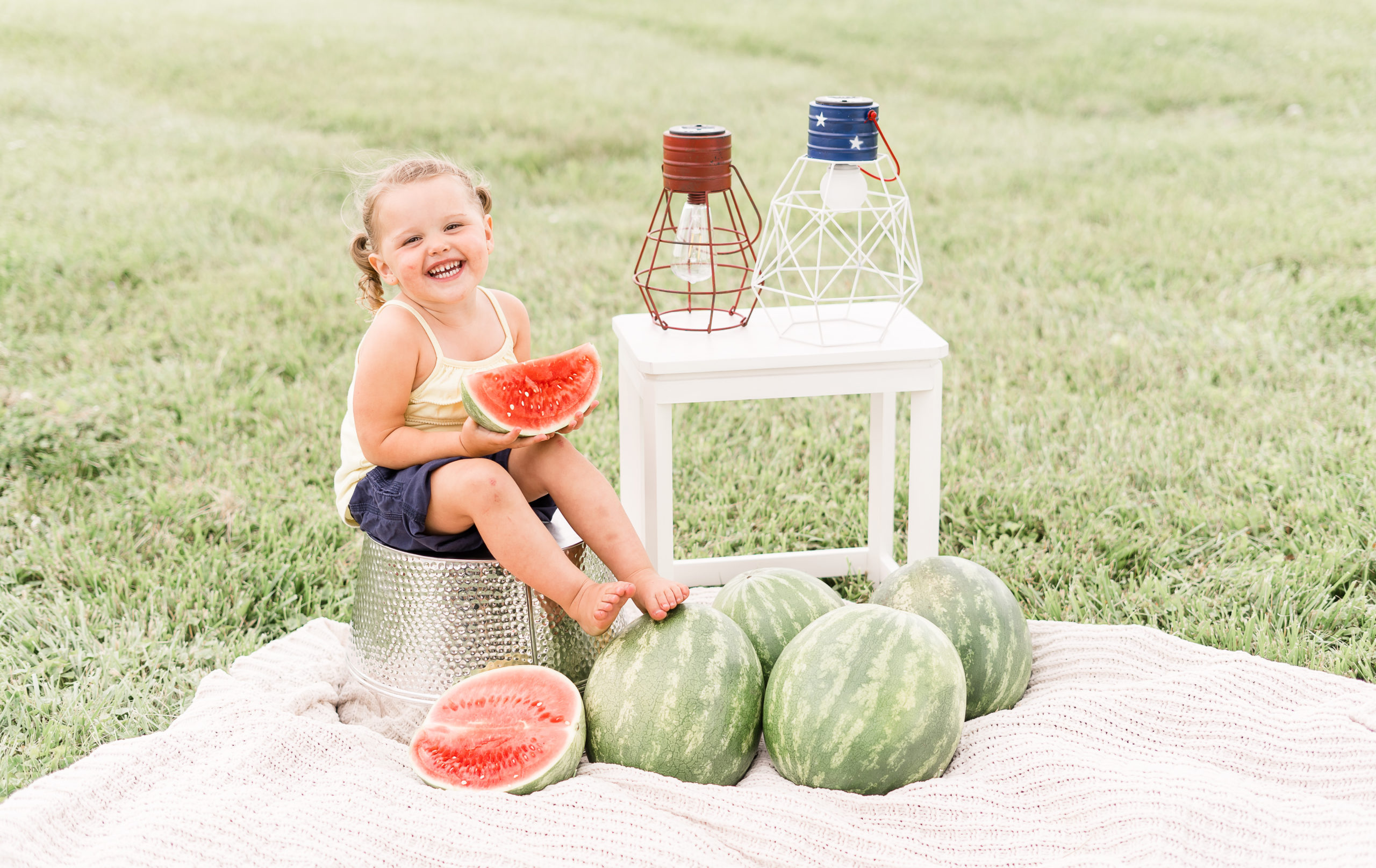 little girl eating watermelon on bucket