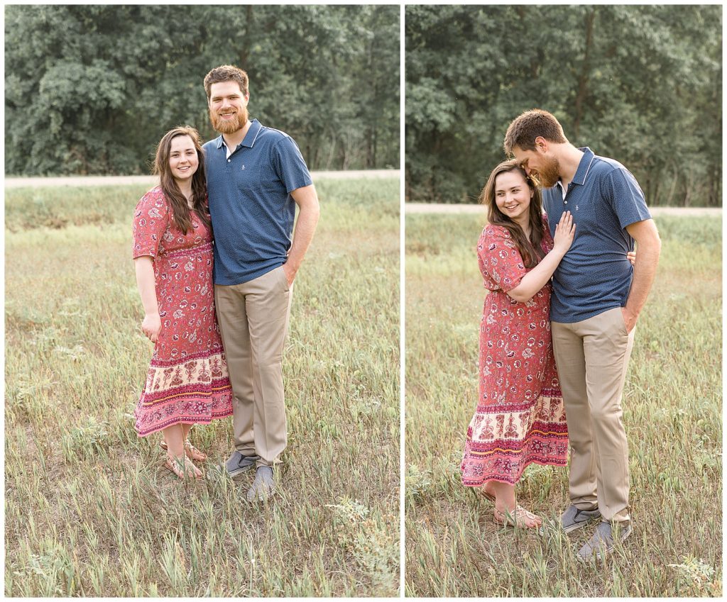 Couple smiling away from camera while standing in a meadow
