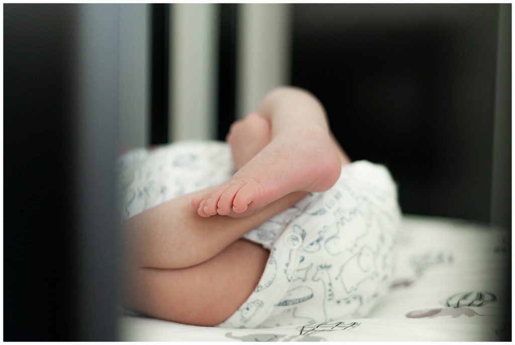 Sweet newborn boy's feet inside crib in Westfield, Indiana